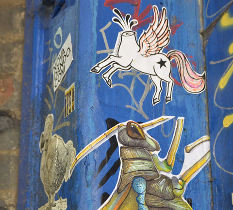 street art and graffiti in Shoreditch England, on Braithwaite Street, paste up of a flying pony with its head cut off, also a dodo bird 