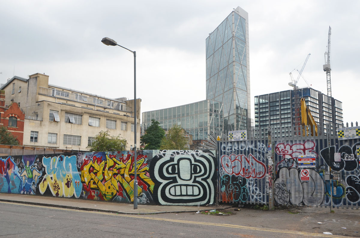 street art and graffiti in Shoreditch England, on Braithwaite Street, construction hoardings covered with street art