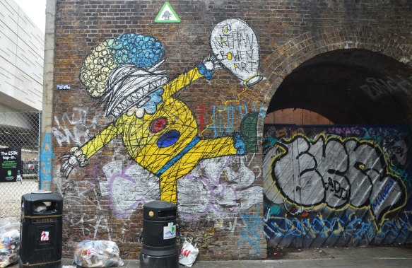 street art and graffiti in Shoreditch England, on Braithwaite Street, a painting by Nathan Bowed on a man in yellow clothes (a clown?)