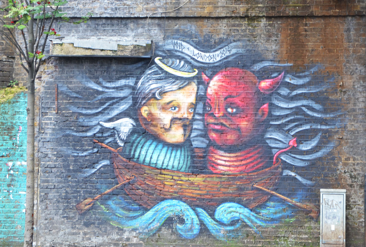 street art painting on a man in a tub floating in the water beside a figure that is the red devil beside him. 