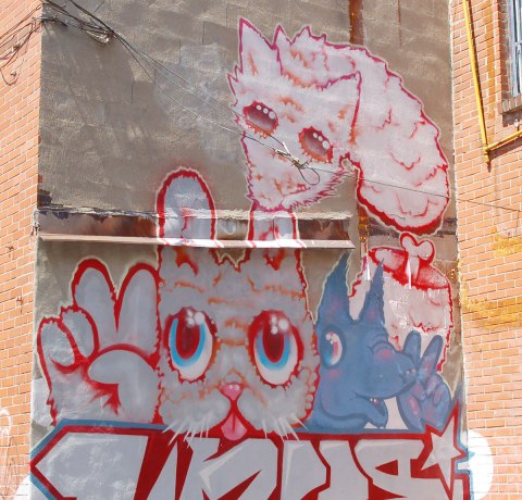 street art, graffiti, animals painted on a wall - a pink cat and blue dog, both giving a peace sign