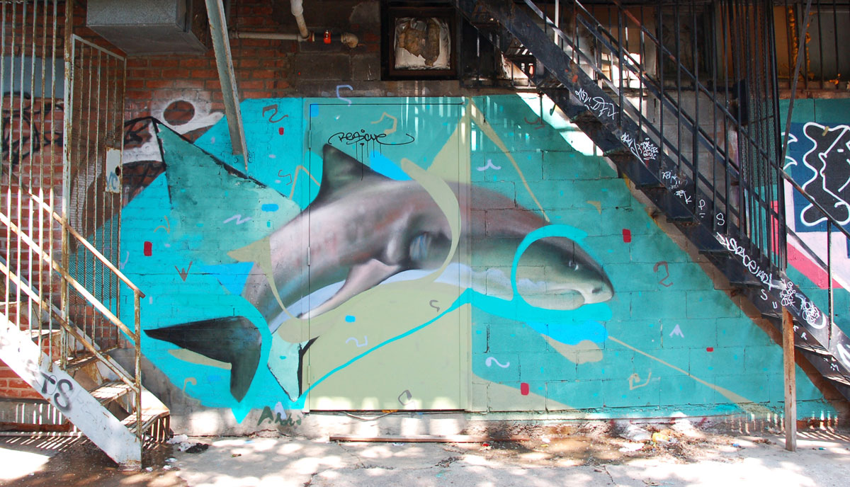 street art, graffiti, animals painted on a wall - a dolphin is swimming under exterior metal staircases