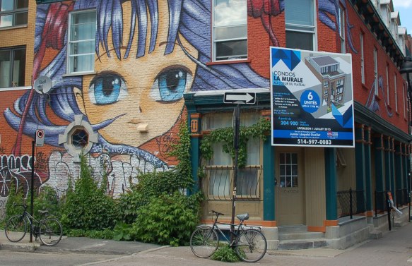 large painting of a girl's face with bright blue eyes and purple hair 