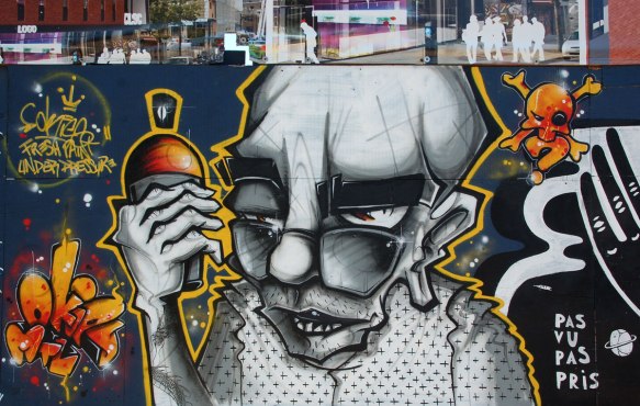 fresh paint under pressure, a man is holding a spray paint can. he is old looking, bald, with glasses at the end of his nose, wearing a top with black polka dots, done in grey tones