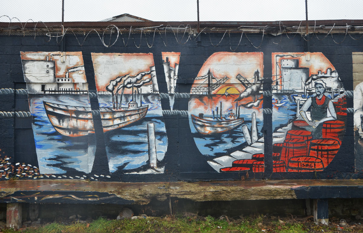 part of a larger mural, a dock scene, harbour, ship in the water, lift bridge open in the background, kegs and barrels on the dock, a man working on the dock 