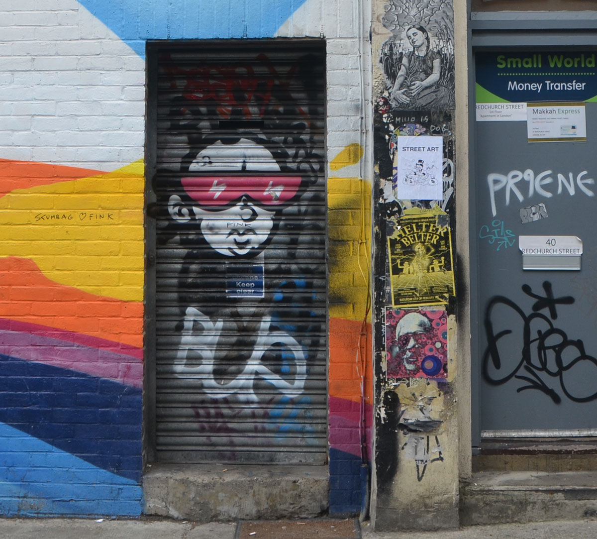 graffiti on a black metal door, a face with big red glasses 