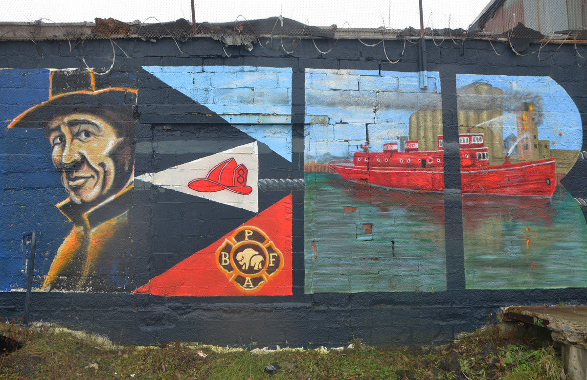 part of a large mural celebrating the workers of Buffalo, this panel is for the police and firemen and includes a red fire boat. 