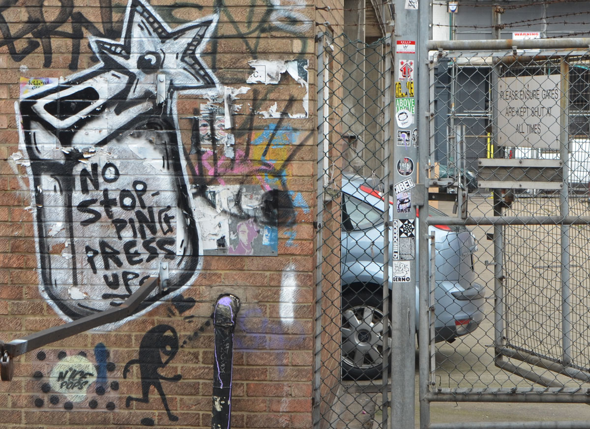 graffiti on a brick wall including a little stick figure man with a large head by n'ice pops, and the words no stopping 