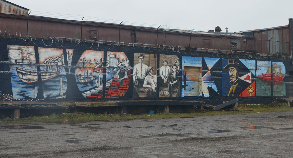 the word worker is written in large capital letters and each letter contains an image of people working, a large mural in Buffalo New York 