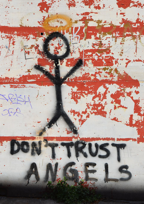 street art in Thessaloniki Greece - stick figure person with a yellow halo and the words underneath: Don't trust angels 