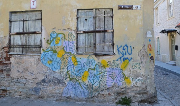 stylized flowers and leaves in pastel colours, line drawings, on a pale yellow wall