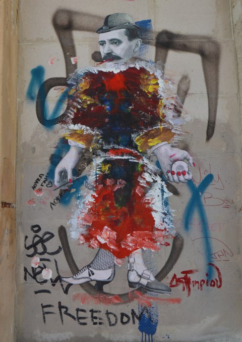 a black and white paste up of woman that has been painted over with many colours except for the head, hands and feet (wearing old fashioned shoes)