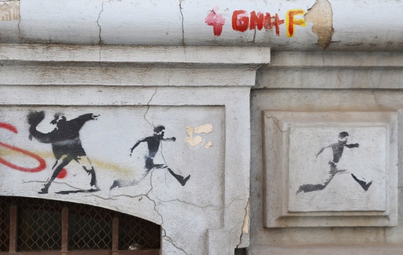 three stencils in a row, on the left a man throwing something, the next two are men running away 