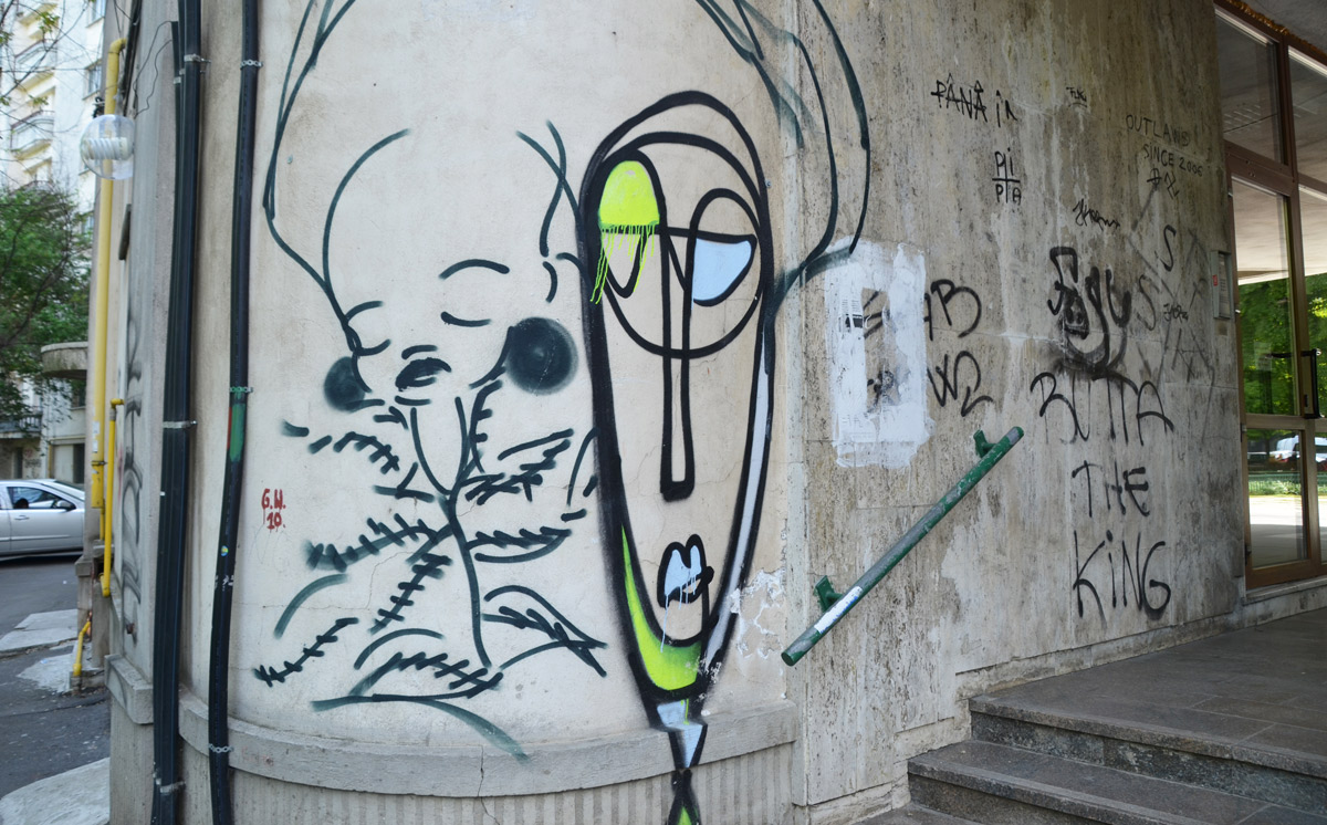 two line drawn graffiti faces on a concrete wall 