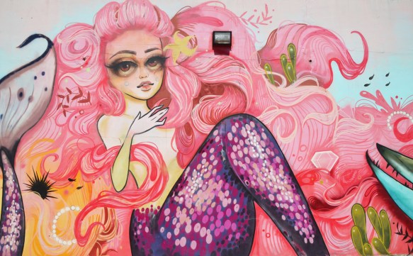 part of a larger mural by Tati Suarez, @tatunga, of mermaids - long pink hair, purple scales on fin, 