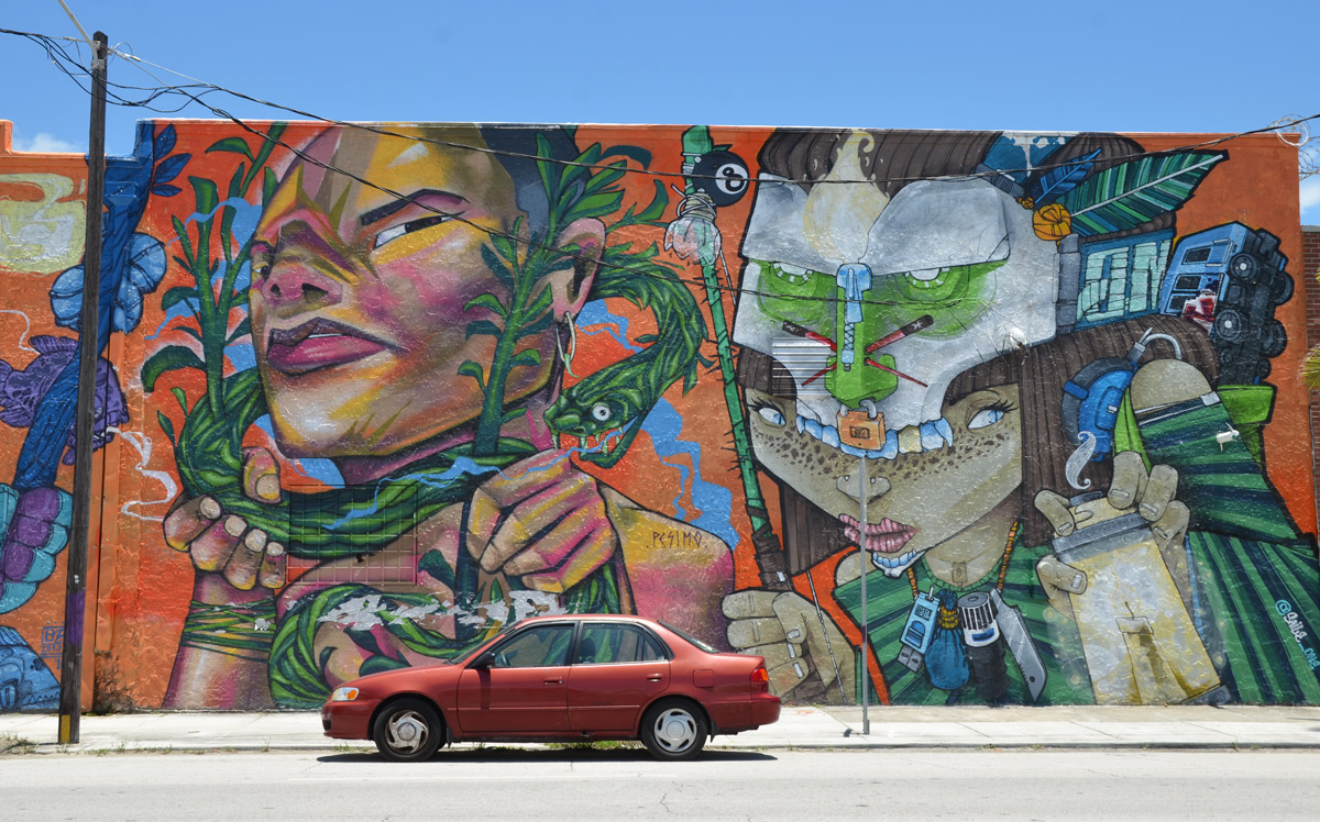 large mural by pesimo93, dmjc crew and saile_one - part of the mural with a red car parked in front of it.