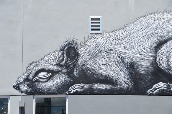 small rodent sleeping on top of a window, black and white mural by ROA