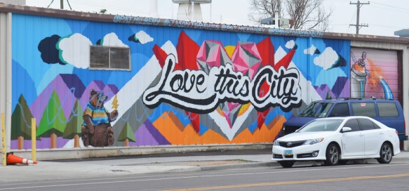 horizontal mural in Denver with cursive writing that says Love this city. 