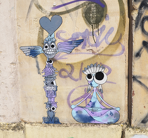 two little purple and white characters on a beige wall, a red heart is above the head of a tall skinny standing creature while the other is sitting crossed legged beside him