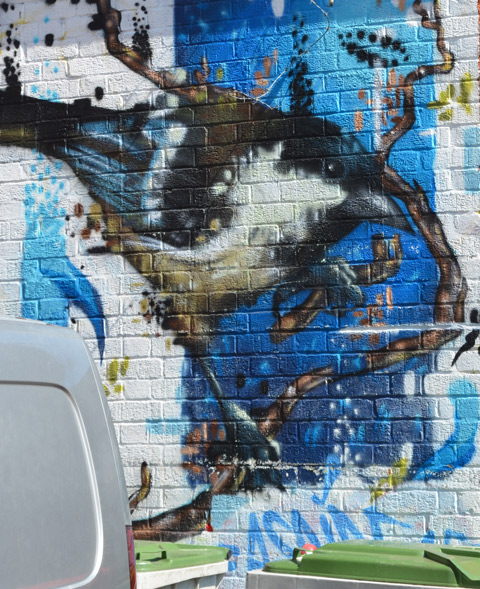street art mural of a bird, blue and grey and black 