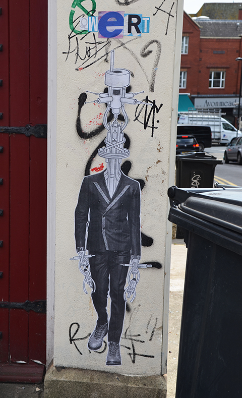 vertical paste up, man in suit and good shoe, but with head and hands as machinery