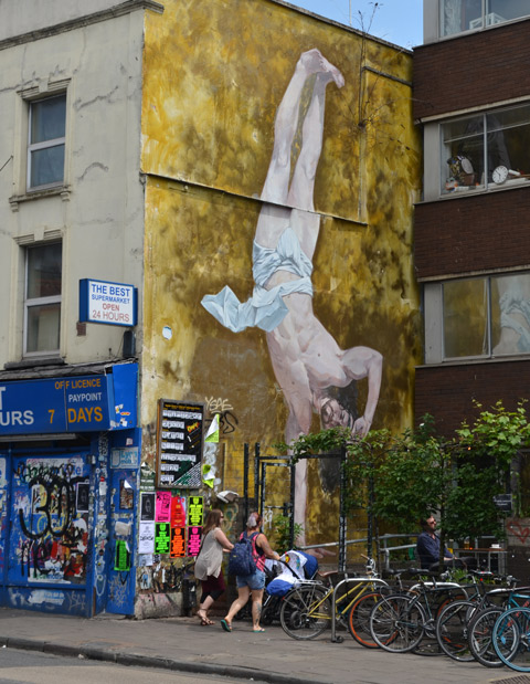 large mural of a man upside down on one hand, only a loincloth on, no other clothes