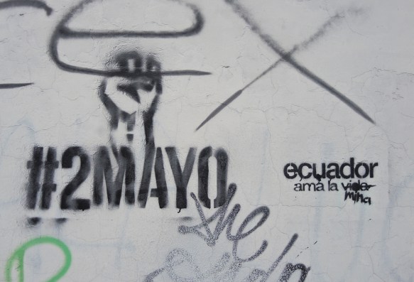 two black stencils, the first is a raised fist with the words #2mayo and the other says ecuador 