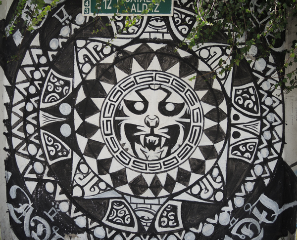 circular pattern painted in black and white with a cat's face ferocious in the center circle, painted mural 