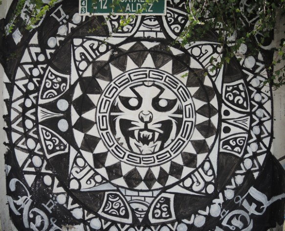 circular pattern painted in black and white with a cat's face ferocious in the center circle, painted mural 