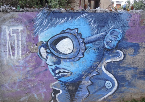 mural of a boy's head in profile, short hair, wearing goggles, all in blue shades 