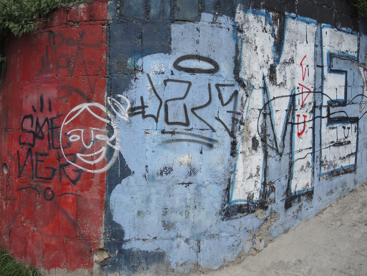 wall painted part red and part blue. on the blue part is a large ME in white with black border. Quito Ecuador graffiti
