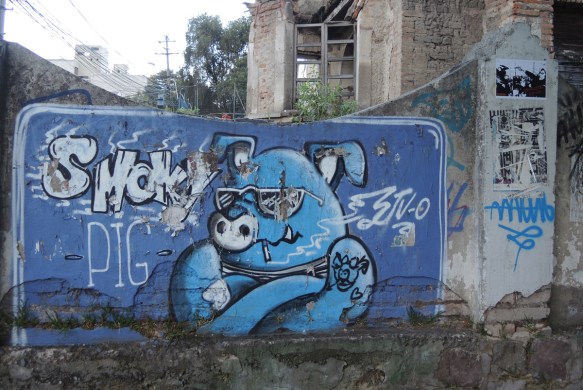 painted in blue, a pig with sunglasses and crossed arms, words say smoky pig 