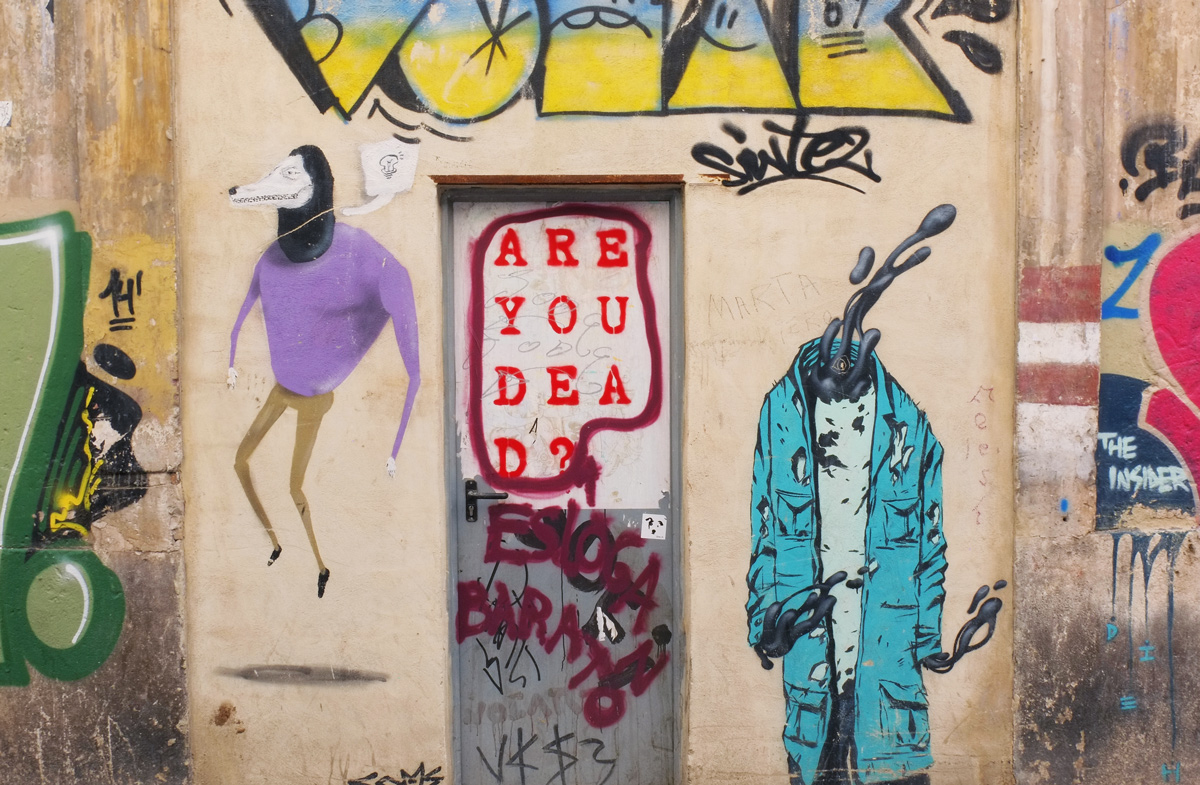 several pieces of street art on a wall including red words on a metal door that say are you dead 
