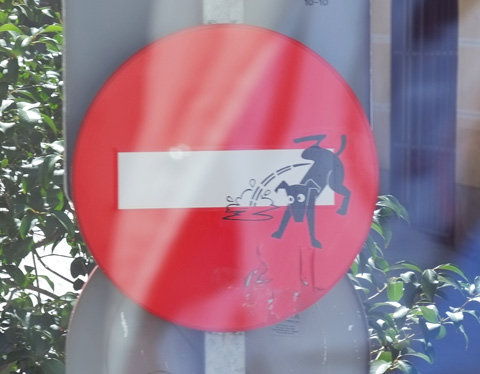 altered do not enter sign with black dog peeing on the white bar