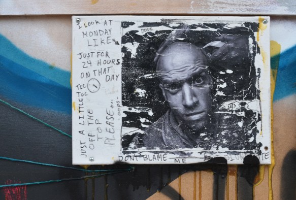 picture of a man in black and white, mount on a wall, weathered, some writing around the edges 