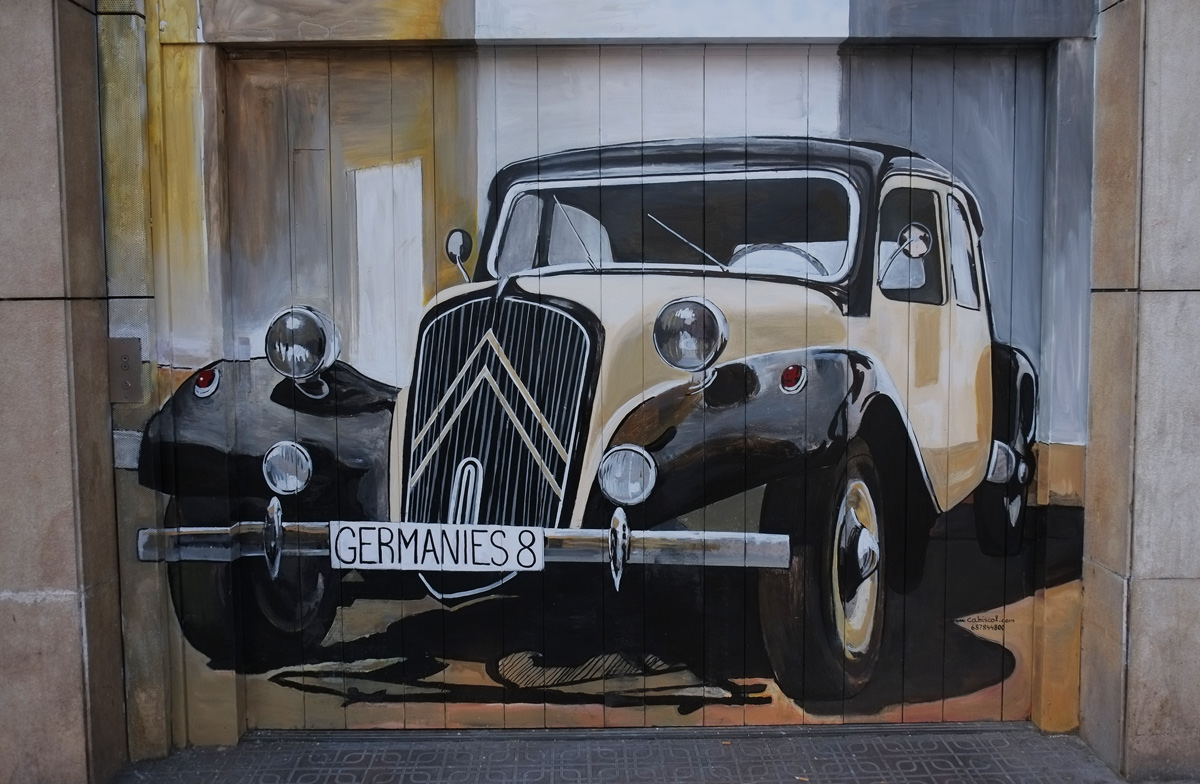 street art of an old car painted on a garage door - licence plate says germanies 8 