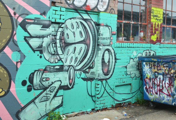 light green mural, black line drawing of an airplane? or a gun?