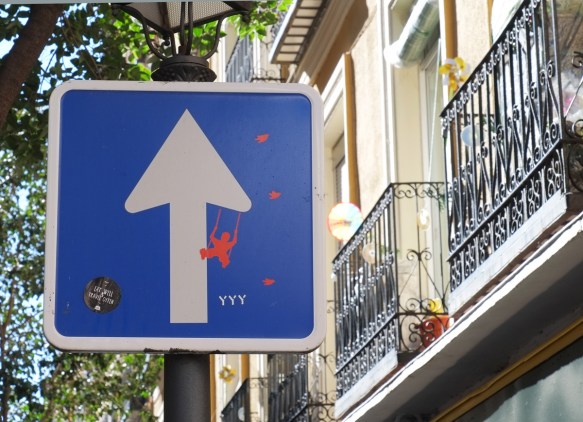 one way sign, arrow is a tree with a pink swing