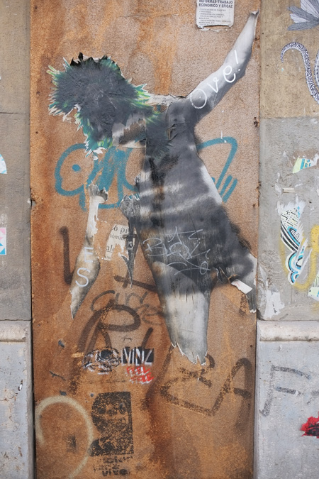 damaged pasteup of the back of a woman in short skirt and shoulder length hair. 
