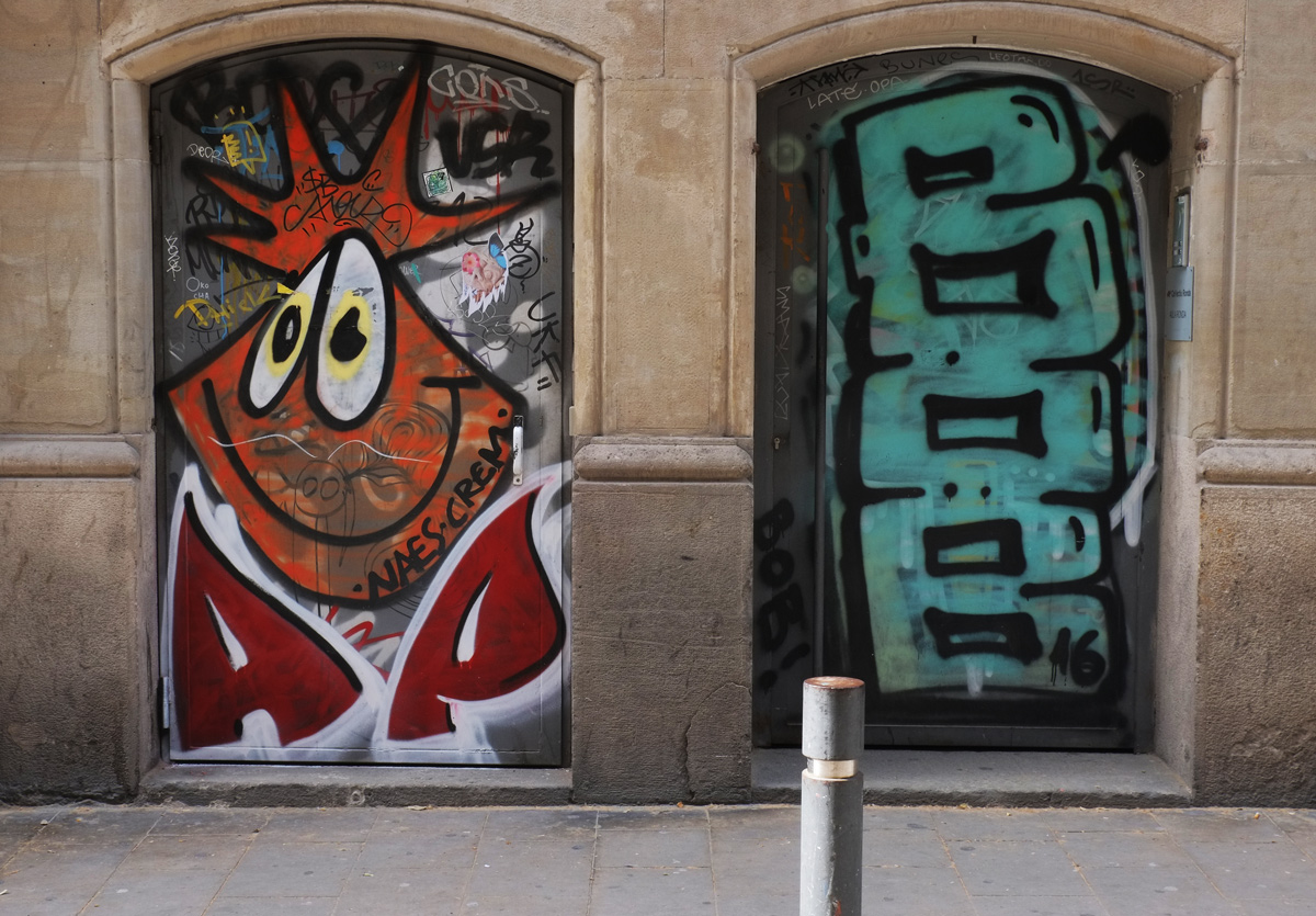 two doors with murals. on the left is goofy faced creature with orange spiky hair and on the right is the word BOB written vertically in large light teal letters. 
