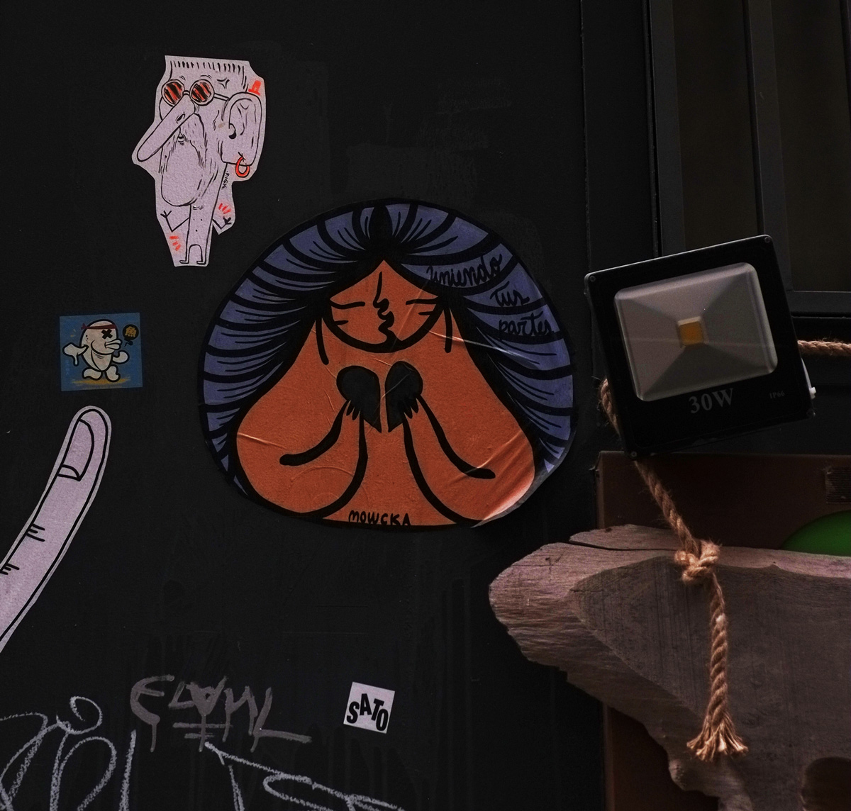 stickers and paste ups on a wall 