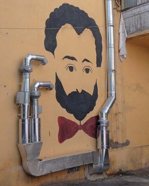 yerevan street art, man's head, black hair and beard, red bow tie, on yellow wall