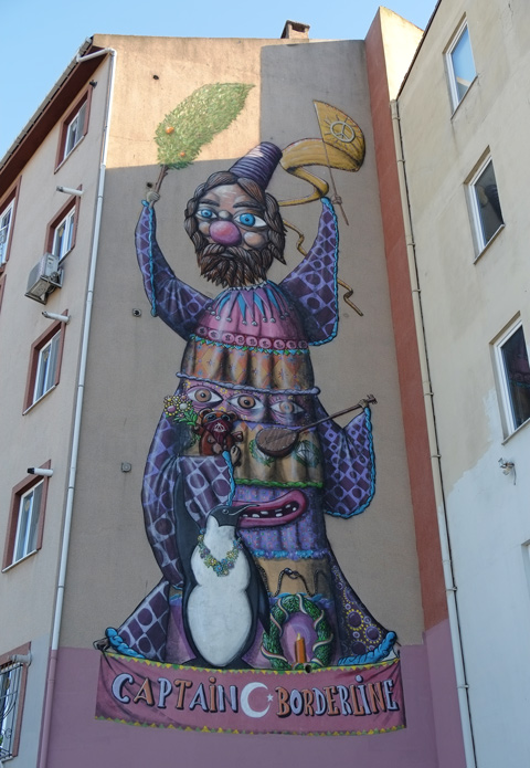 large mural in Kadikoy Istanbul, a man, clownish features, black bears, standing up, 