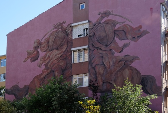 large purple hued mural in Kadikoy, two horsemen facing each other with a column of windows in the middle, by Argentinian artis Jaz 