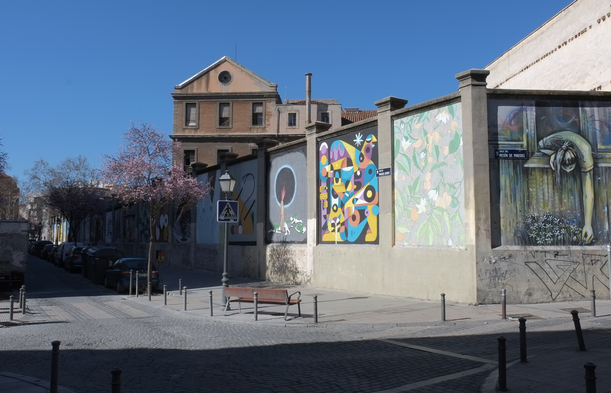 street scene in Madrid, murals on a high concrete wall, muros tabacalera, 