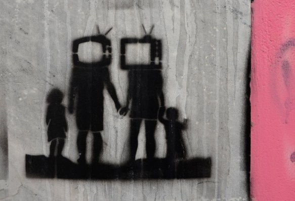little black stencil of a family, parents have televisions for heads, standing in a row, all holding hands. seen in Athens Greece 