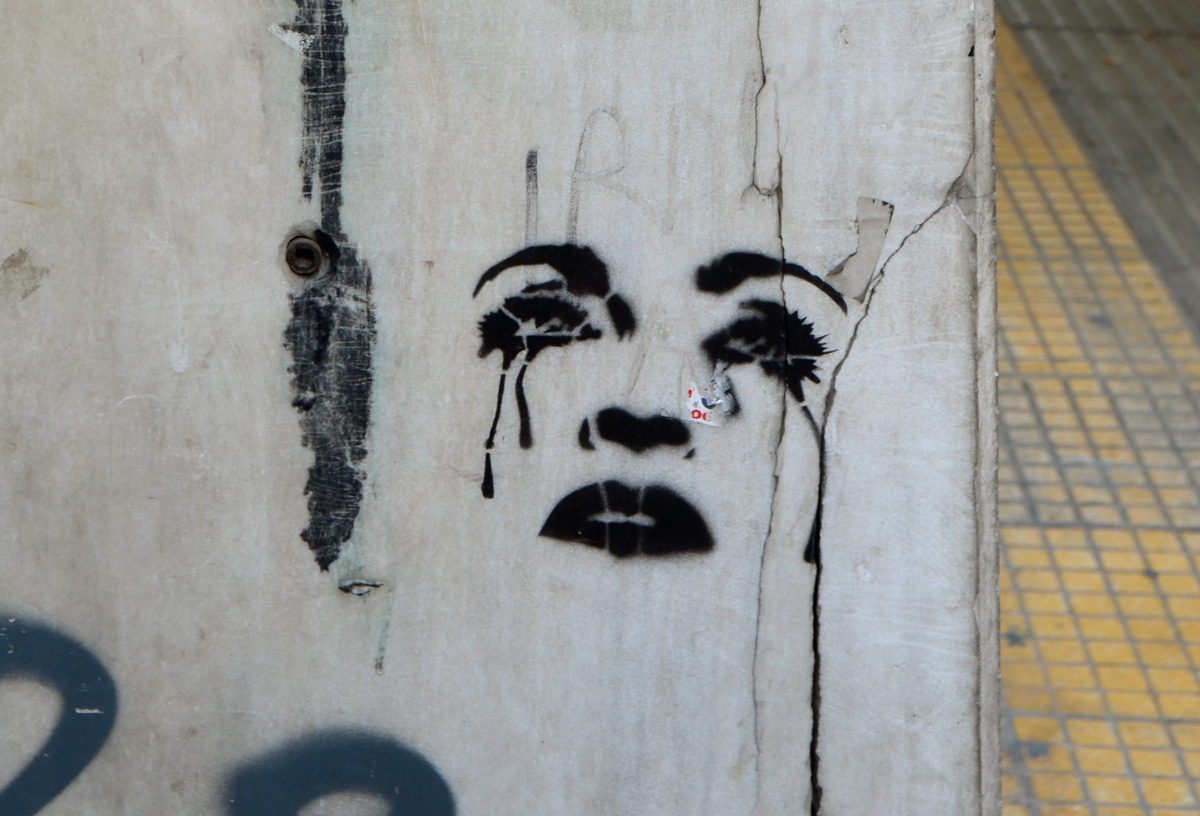 black stencil of a woman's face, just the features, she is crying and black tears are running down her face