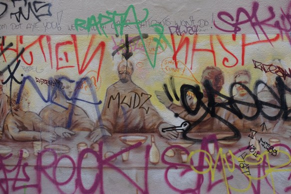 once it was a sepia toned painting of the last supper (religious) but it has had a lot of graffiti written on top of it 