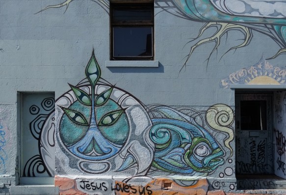a street art liion in blues, stylized, also a fish, on a wall under a window and beside a door, by phibs in 2015, on a street in Melbourne Australia