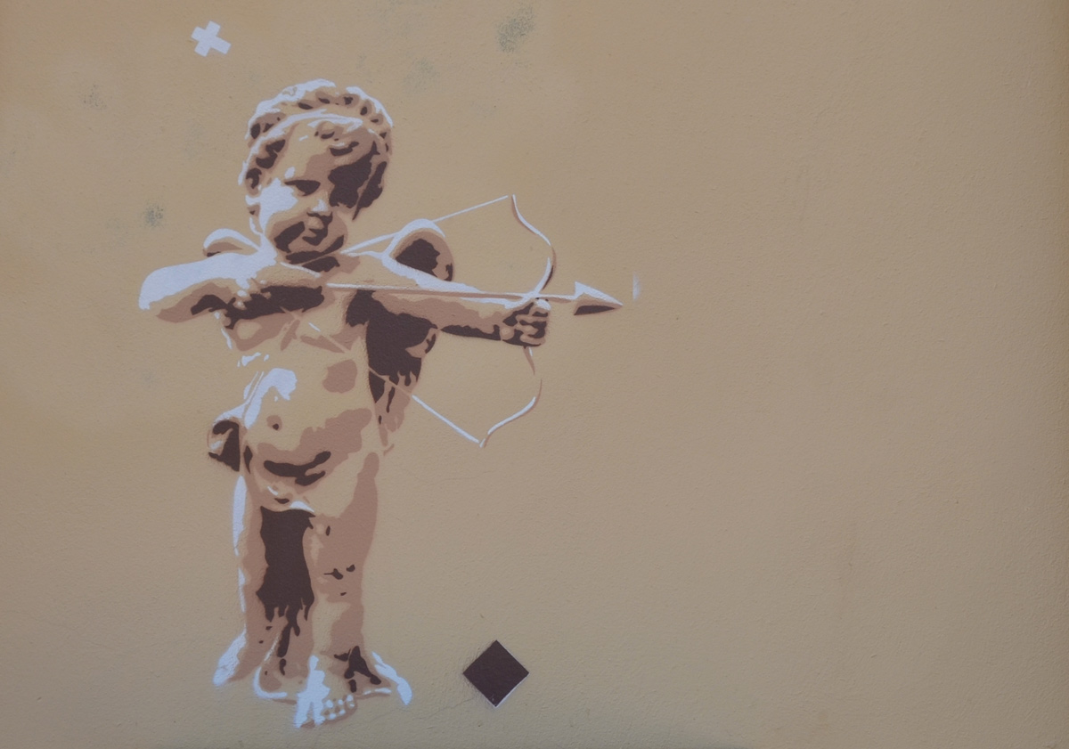 a small graffiti piece of a small chubby partially naked cupid with an arrow ready to shoot from his bow. 